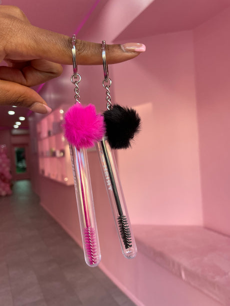 Three Brush & GO lash spoolie keychains lined up – white, black, and pink portable lash brushes with caps Three Brush & GO lash spoolie keychains lined up – white, black, and pink portable lash brushes with caps